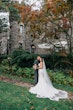 Groom Hugging Bride Wearing A Fitted Lace White Wedding Dress Named Veronique by Maggie Sottero