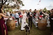 Bride and Groom are Joined in Walking Down the Isle with their Dogs. Bride in Vintage Inspired Puff Sleeve Mermaid Wedding Dress in 3-D Floral Motifs Called Cruz by Sottero & Midgley