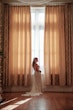 Bride wearing Bailey by Sottero and Midgley in front of curtains