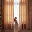 Bride wearing Bailey by Sottero and Midgley in front of curtains