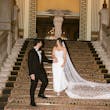 Bride Wearing Sheath and Beaded Wedding Dress Called Doritte By Maggie Sottero Walking Down The Stairs With Groom