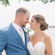 Bride Wearing Boho Sheath Wedding Dress Called Marisol By Rebecca Ingram With Groom Holding White And Pink Bouquet