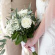 Bride wearing Davis Leigh wedding dress by Sottero and Midgley holding her bouquet