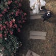 Bride Wearing Lace Aline Bridal Gown Called Harlem By Maggie Sottero Holding Hands With Groom In A Garden