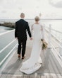 Bride wearing Bethany wedding dress by Rebecca Ingram walking with her husband