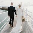 Bride wearing Bethany wedding dress by Rebecca Ingram walking with her husband