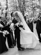 Bride Wearing Simple Fit And Flare Wedding Dress Called Mitchell Marie By Maggie Sottero Kissing Groom