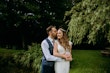 Groom kissing bride's head with arms around her.