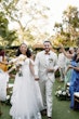 Bride wearing Lettie by Rebecca Ingram walking out of their ceremony