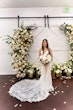 Bride Wearing Lace Fit And Flare Wedding Dress Called Fairchild By Maggie Sottero Next To The Flower Arch