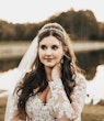 Bride Wearing Lacey Sheath Long Sleeve Wedding Dress Called Francesca By Maggie Sottero And Veil Outside By Water