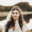 Bride Wearing Lacey Sheath Long Sleeve Wedding Dress Called Francesca By Maggie Sottero And Veil Outside By Water