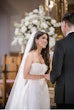 Bride wearing Barcelona by Sottero and Midgley holding her husband's hand during their ceremony