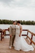 Bride wearing Tuscany Marie wedding dress by Maggie Sottero standing with her husband