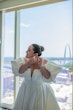 Bride wearing Juniper by Sottero and Midgley putting in earrings