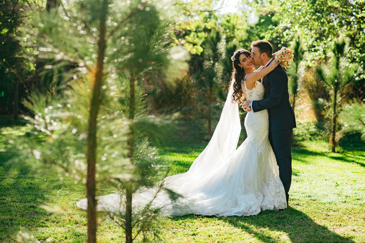 Groom Kissing Bride Wearing Wedding Dress Called Giana Lynette by Maggie Sottero