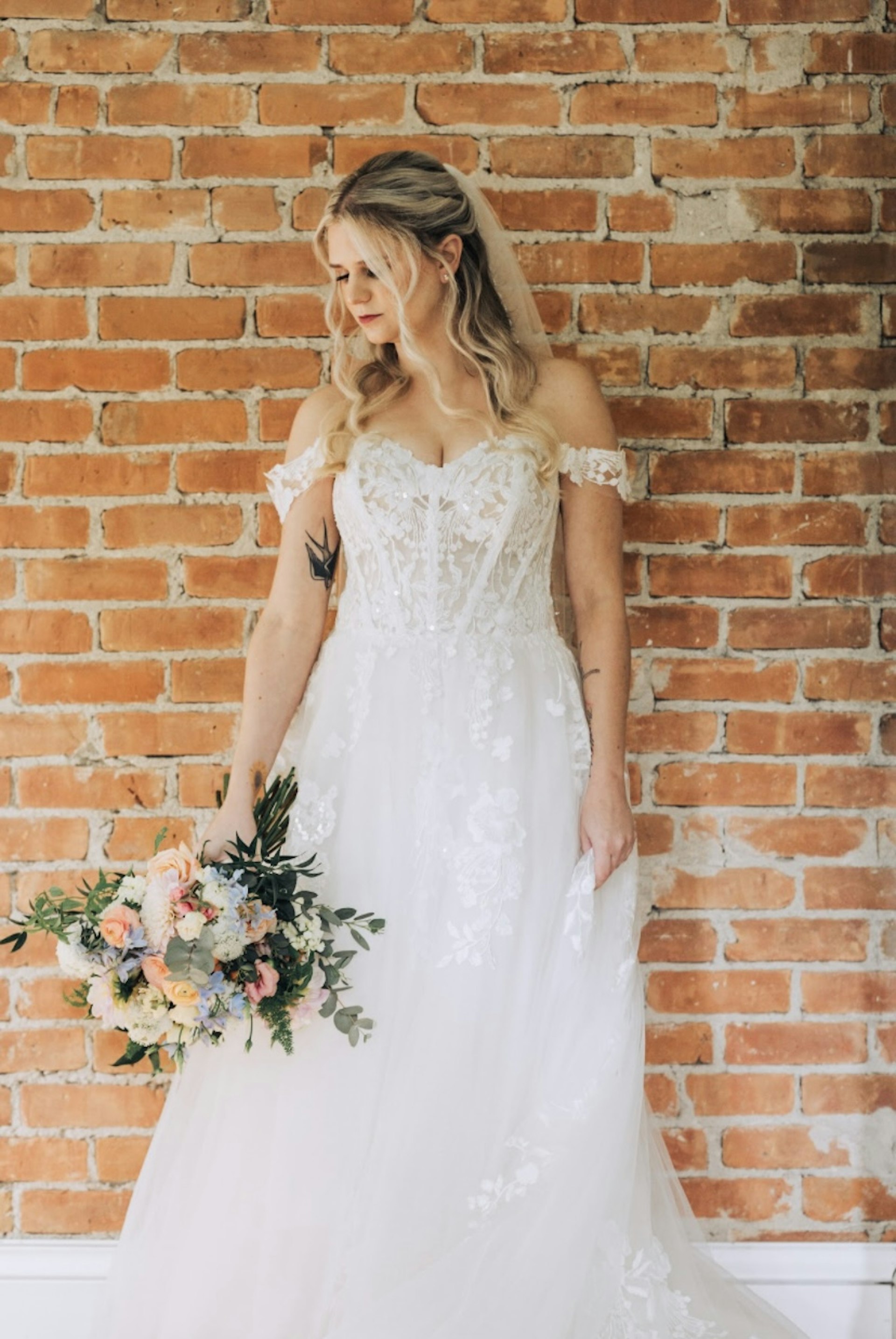 Bride Wearing Lace Aline Bridal Gown Called Harlem By Maggie Sottero Holding Pastel Bouquet