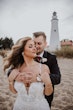 Bride Wearing Beaded Fit-n-flare Wedding Dress Called Jonah Lane By Sottero And Midgley With Groom Next To A Lighthouse