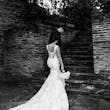 Bride Wearing Lace Backless Wedding Dress Called Chauncey By Sottero And Midgley Walking Up Steps With Groom