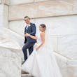 Bride wearing Marvine wedding gown by Sottero and Midgley walking up the stairs with her husband