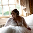 Smiling Bride Sitting in Wedding Gown Called Mallory Dawn by Maggie Sottero
