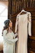 Bride Looking At Her Simple Long Sleeve Wedding Dress Called Bethany By Rebecca Ingram