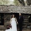 Bride Wearing A-line Bridal Dress Ainsleigh By Rebecca Ingram Holding Hands With Groom Next To An Abandoned Shed