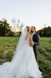 Groom with Bride at Outdoor Wedding Wearing Fairytale Ballgown Called Valona by Sottero and Midgley.