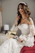 Bride wearing Ryker wedding dress by Sottero and Midgley holding bouquet