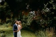 Groom kissing bride wearing wedding dress called Celeste.