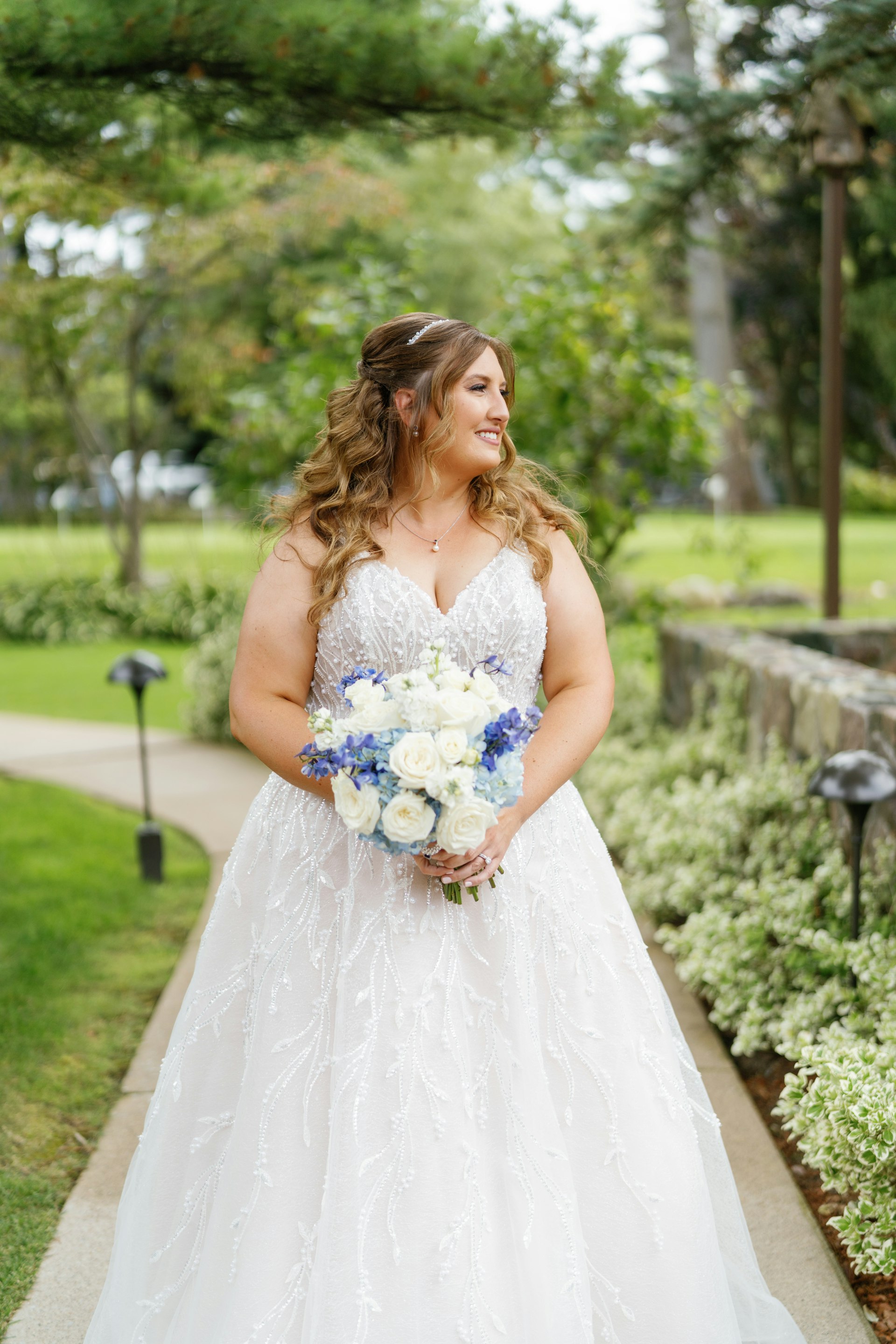 Bride Wearing Beaded Wedding Dress Called Marvine By Sottero And Midgley Holding White And Blue Bouquet