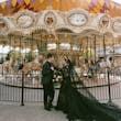 Bride Wearing Black Lace Wedding Dress Called Zander Lane By Sottero And Midgley With Groom In Front Of A Carousel