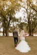 Bride Wearing Pink Lace Mermaid Wedding Dress Called Kenleigh By Sottero And Midgley Walking With Groom