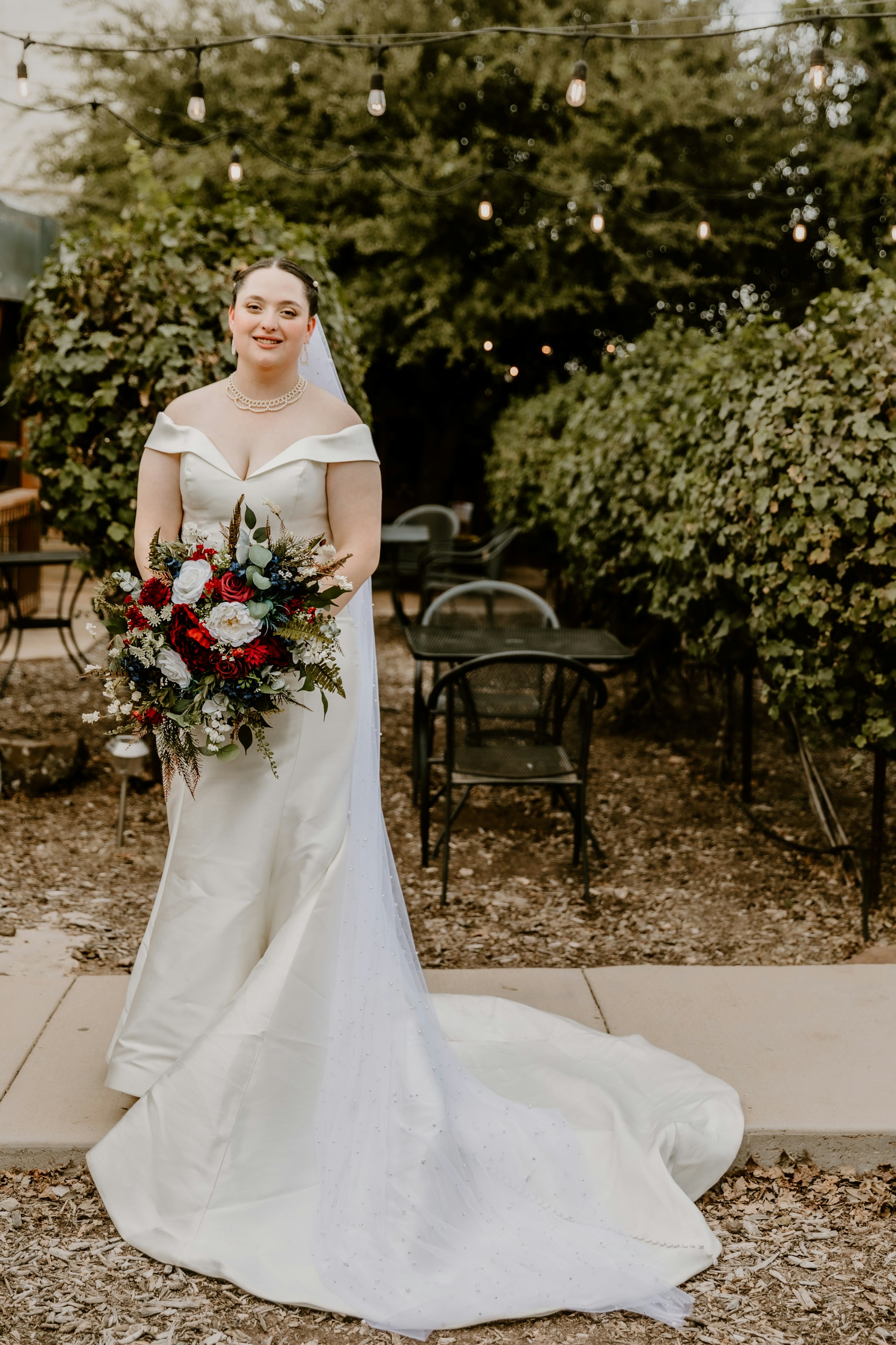 Bride Wearing Simple Fit And Flare Wedding Dress Called Josie By Rebecca Ingram In An Outdoor Patio