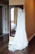 wedding dress called Colbie hanging by mirror.