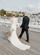 Bride wearing Bethany wedding dress by Rebecca Ingram walking with her husband