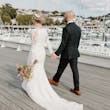 Bride wearing Bethany wedding dress by Rebecca Ingram walking with her husband