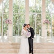 Bride and groom kissing with the sun shining through windows.