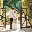 Bride Wearing Aline Wedding Dress Called Nerida By Sottero And Midgley Kissing Groom Next To A Gate