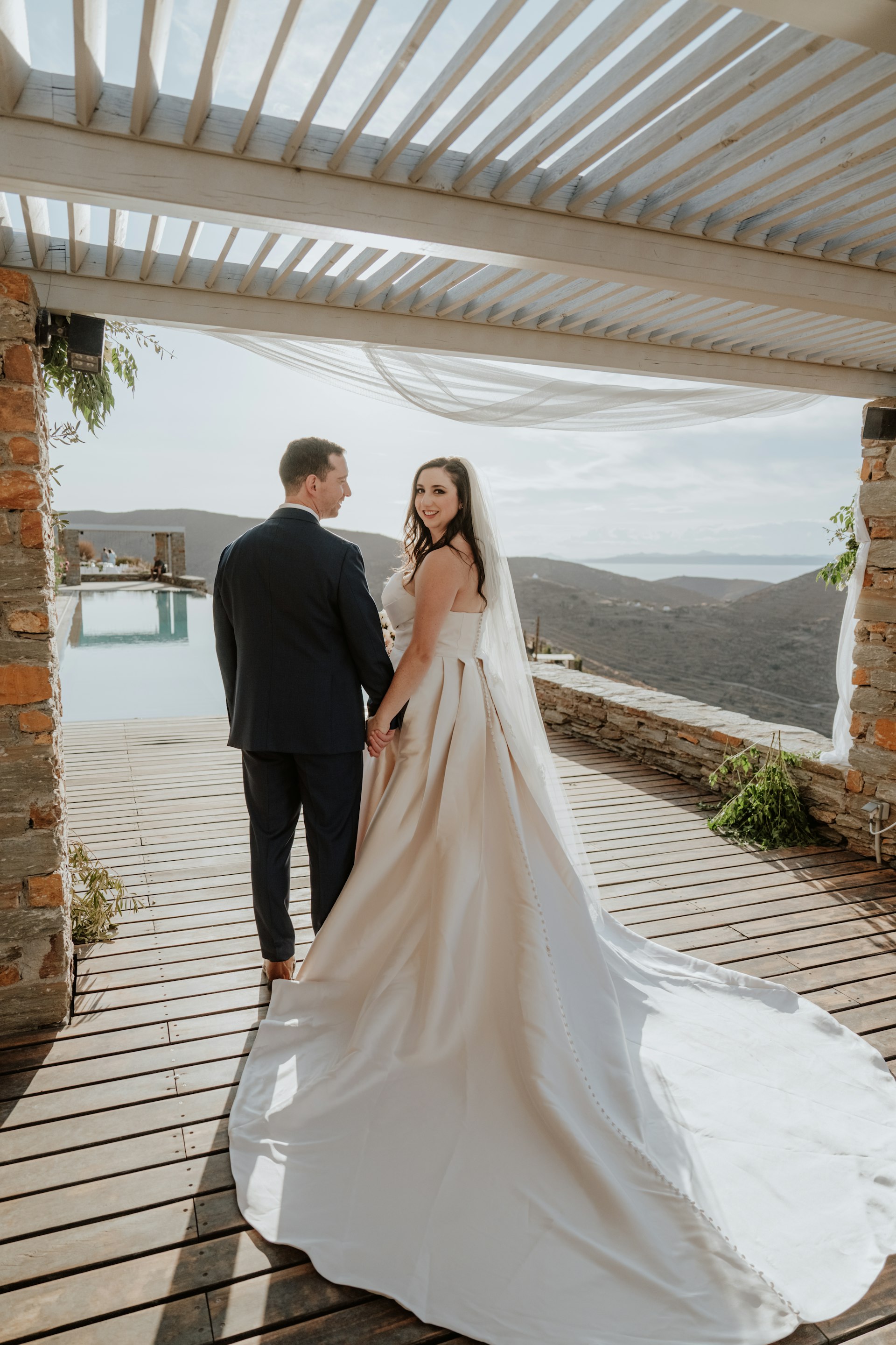 Bride wearing Aspen by Sottero and Midgley holding hands with her husband