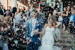 Confetti throw bride and groom laughing.