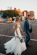 Bride and groom crossing the road on their wedding day.