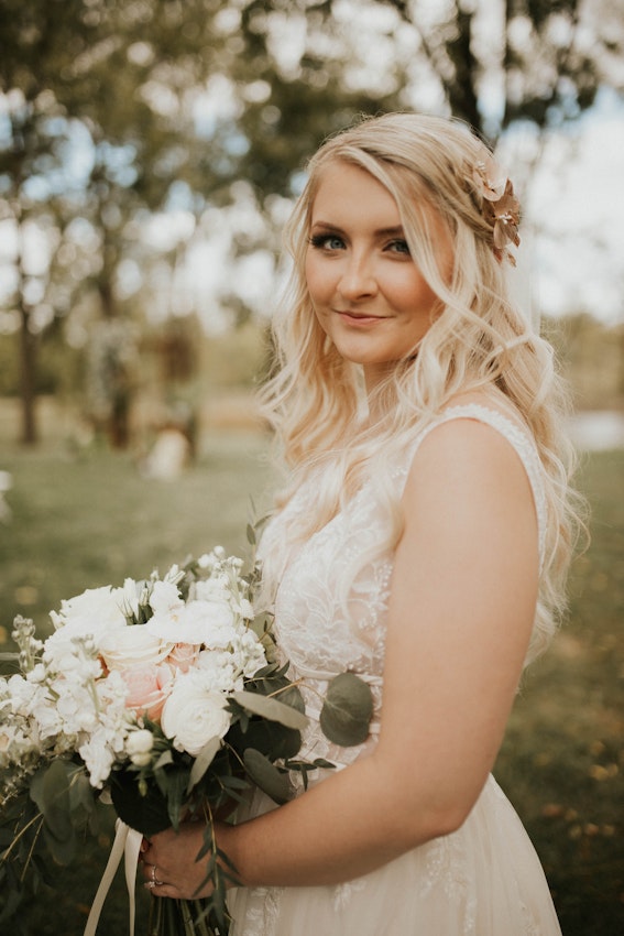 Bride Holding Bouquet Wearing Wedding Dress Called Raelynn by Rebecca Ingram