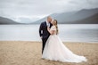 Bride Wearing Lace Aline Wedding Dress Called Harlem By Maggie Sottero With Groom On A Lake Beach