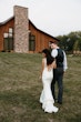 Bride with groom wearing satin sheath wedding dress.