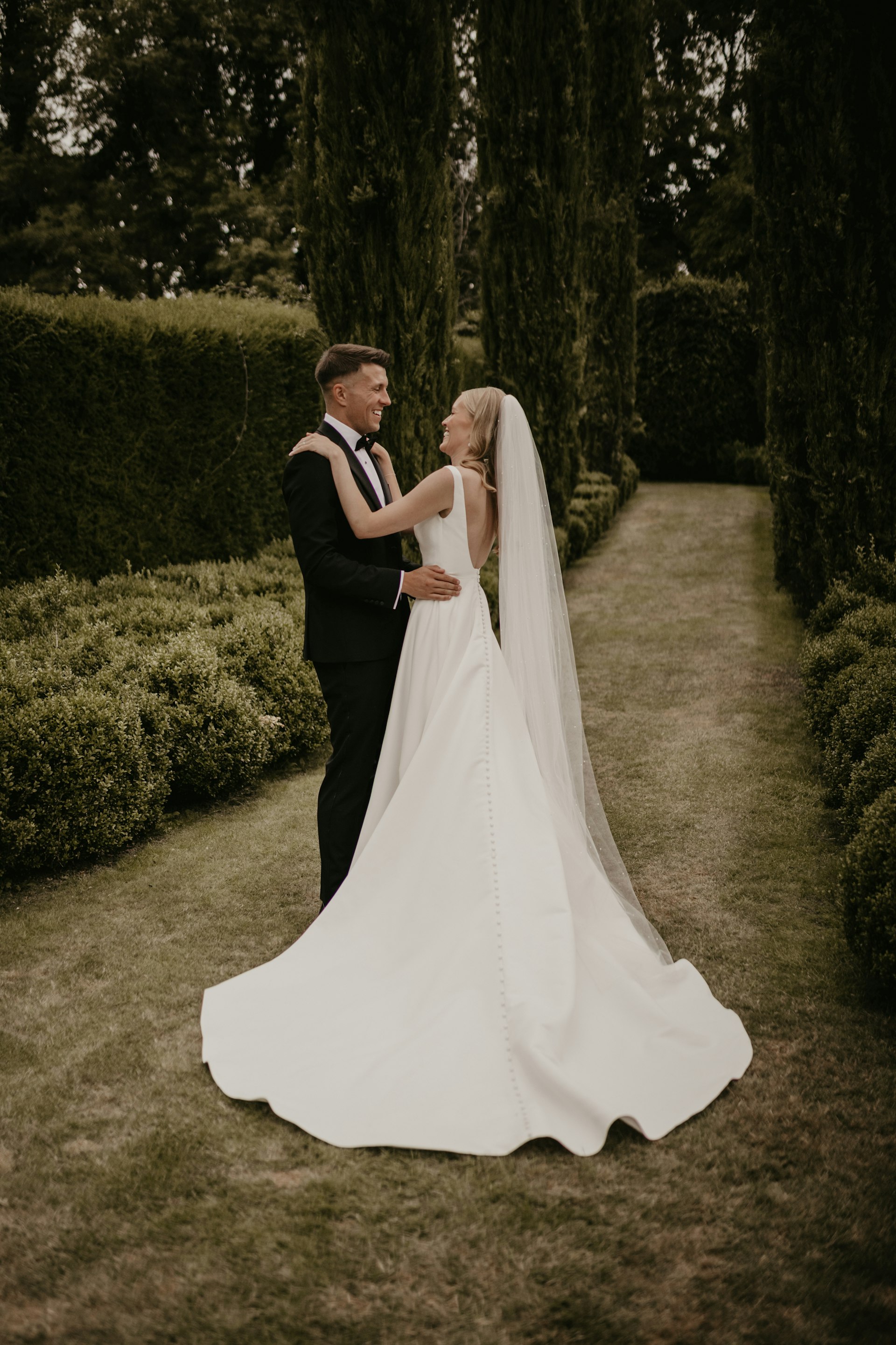 Bride wearing Paxton by Maggie Sottero embracing her husband