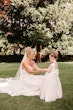 Bride wearing Tuscany Royale by Maggie Sottero holding hands with a little girl