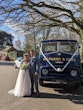 Bride In Long Sleeve Lace Wedding Dress Called Iris By Rebecca Ingram With Groom In Front Of Vintage Car