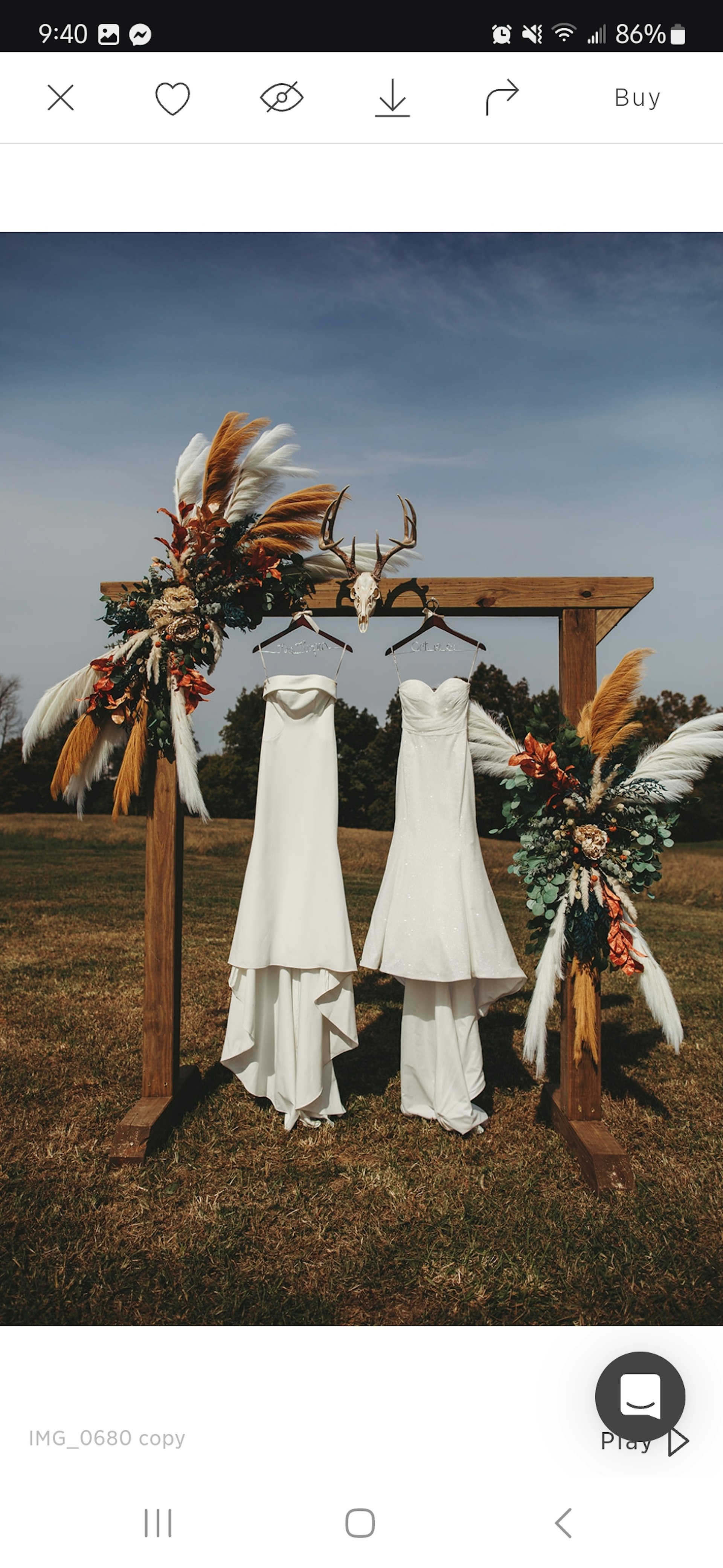 Two Maggie Sottero Wedding Dresses Hanging From A Decorated Post