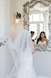 Bride wearing Hattie Lynette wedding dress by Rebecca Ingram looking in the mirror